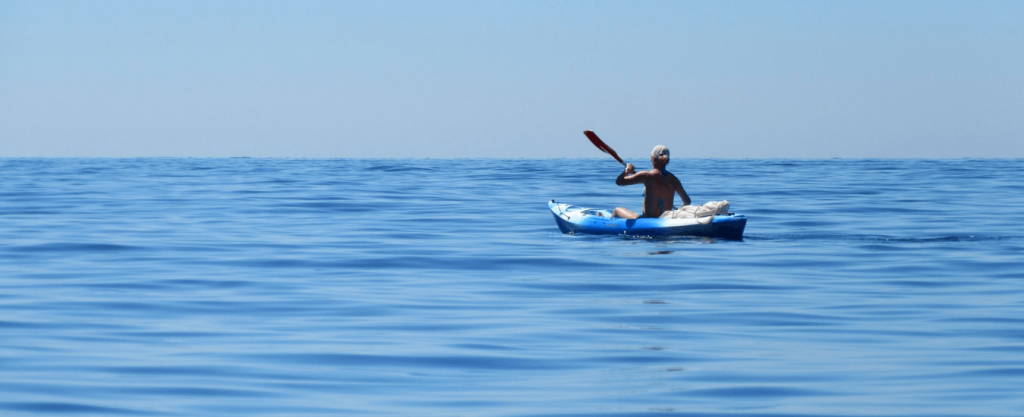 person in a kayak on blue ocean waters